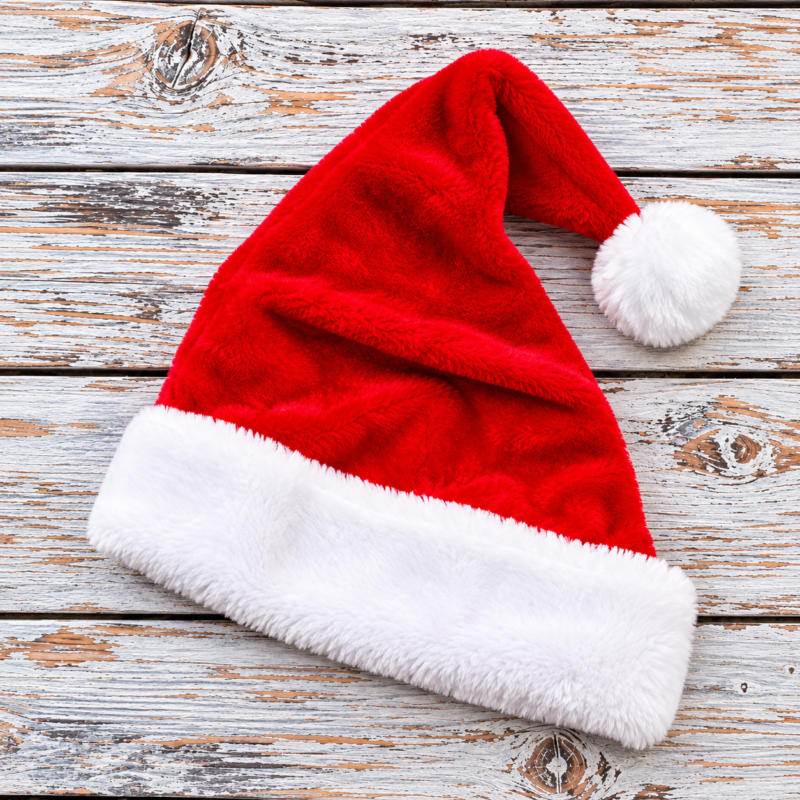 Gorro navideño rojo sobre madera rústica